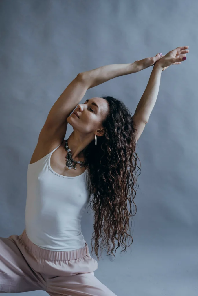 Woman stretching her arms overhead during a calm breathing session